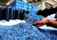 a worker checks a handful of plastic chips